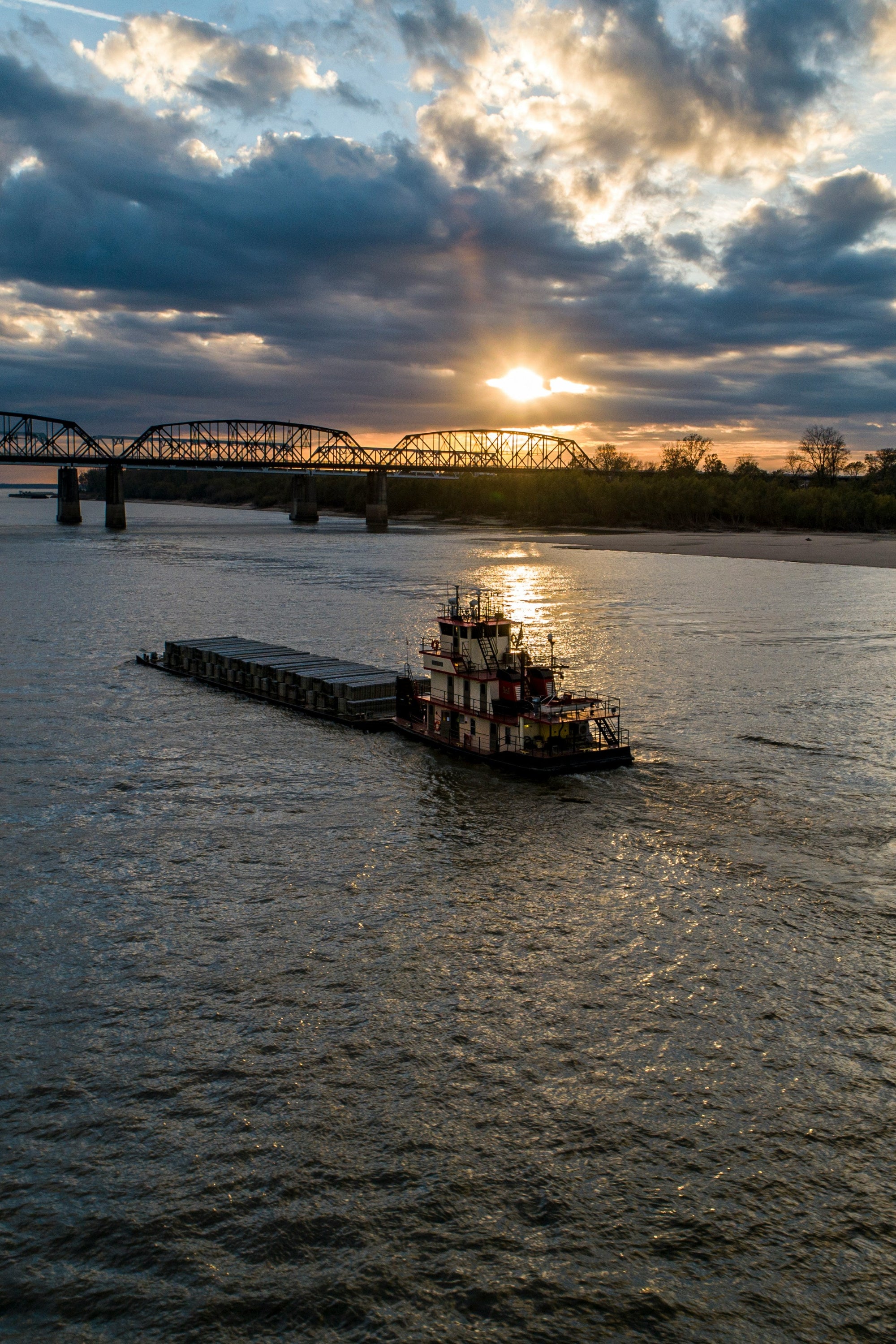 Mississippi River barge and bridge at sunset — FDM Enterprises MRI and CT scanner service coverage across Mississippi