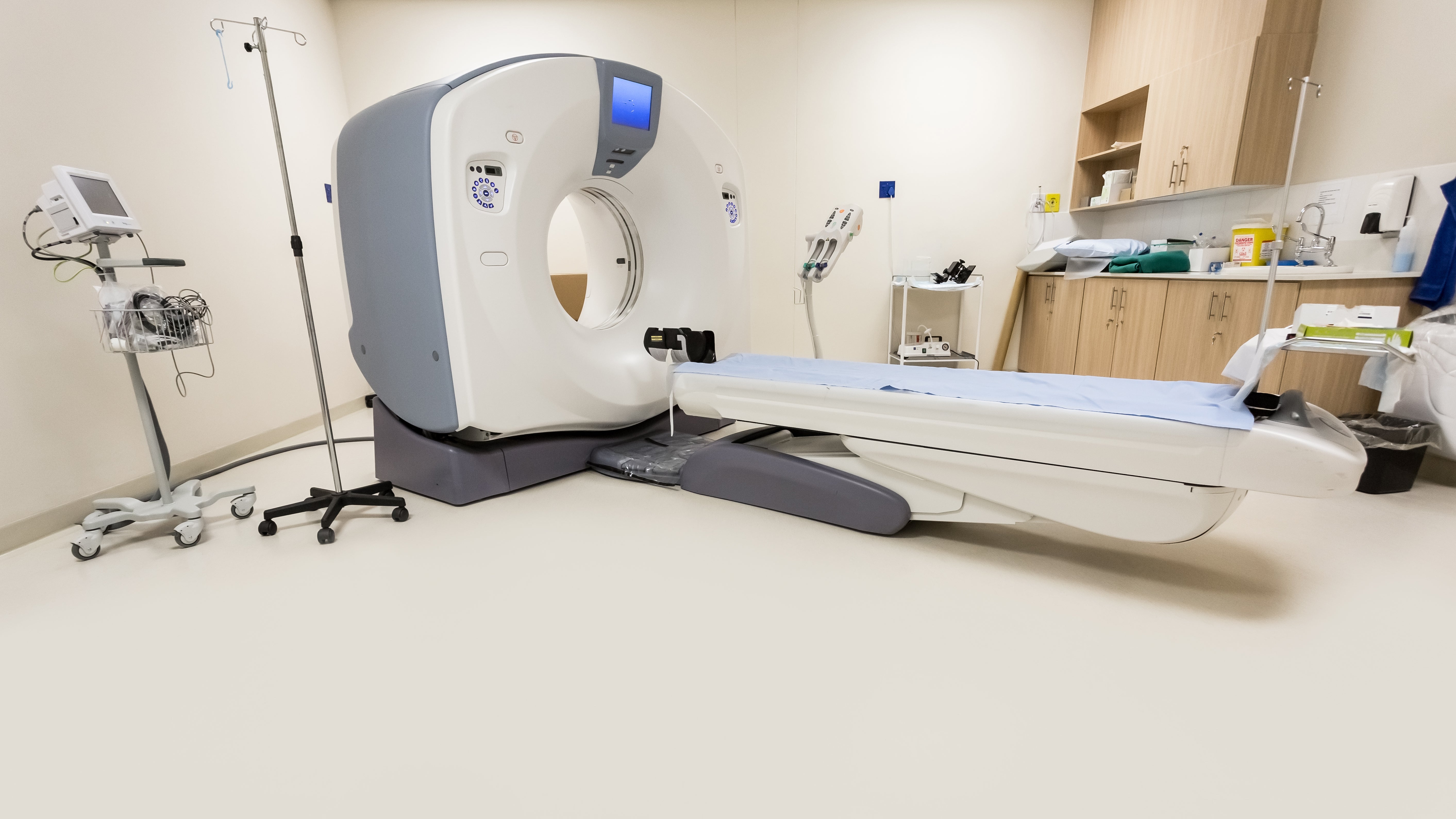 CT scanner room with IV equipment and patient monitoring station