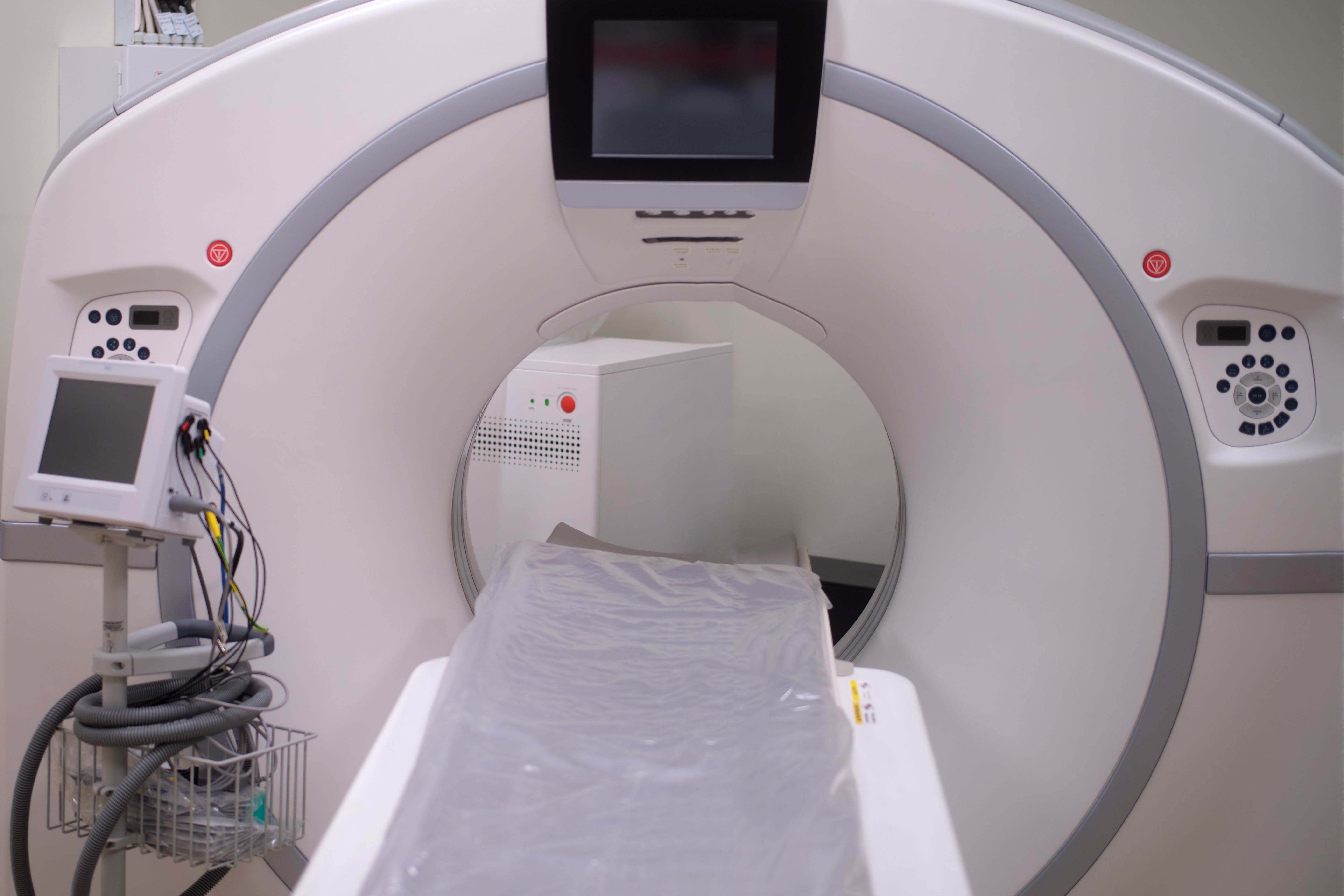MRI machine bore and control panel with patient table ready for scan