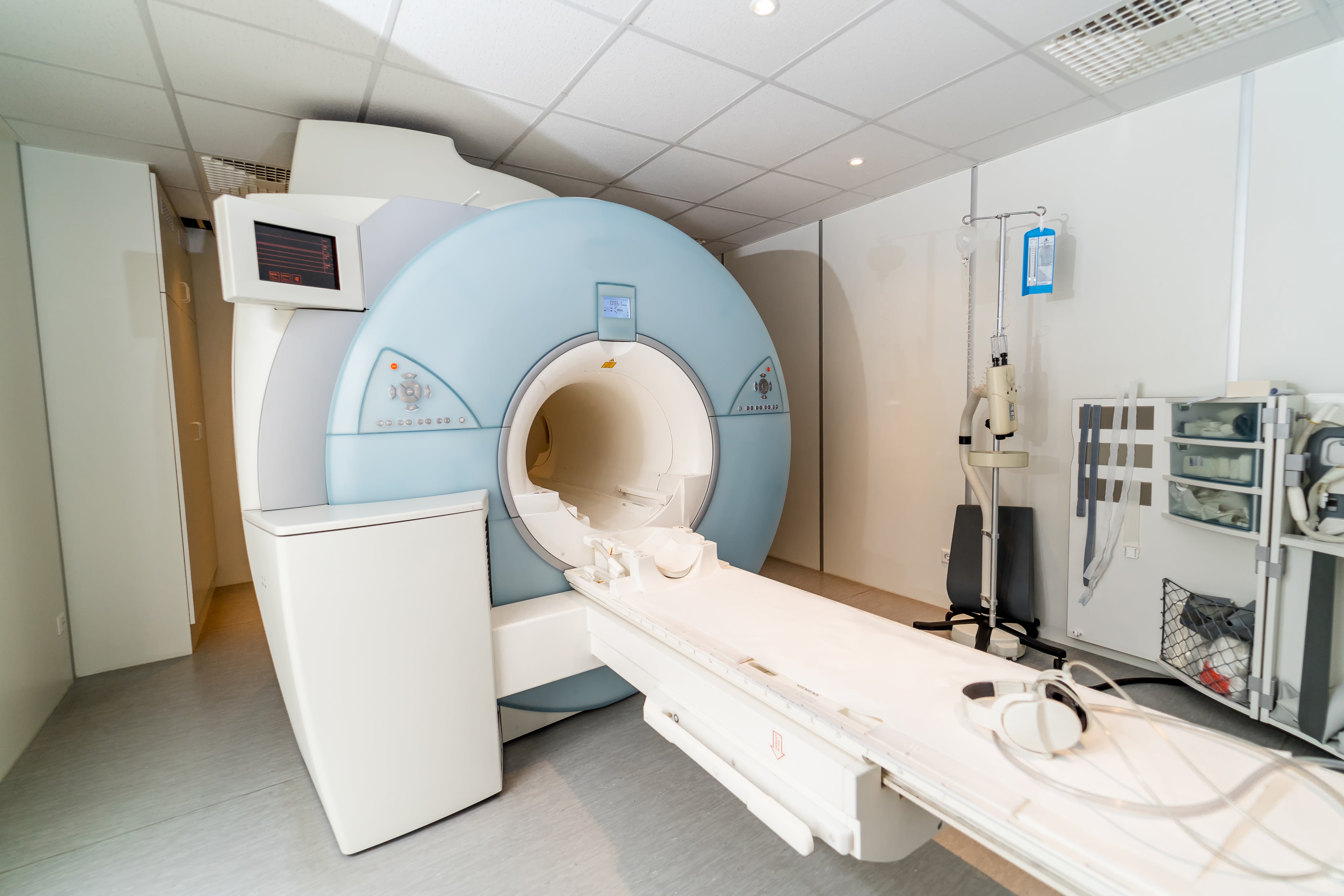 MRI scanner with patient table and head coil in hospital imaging room