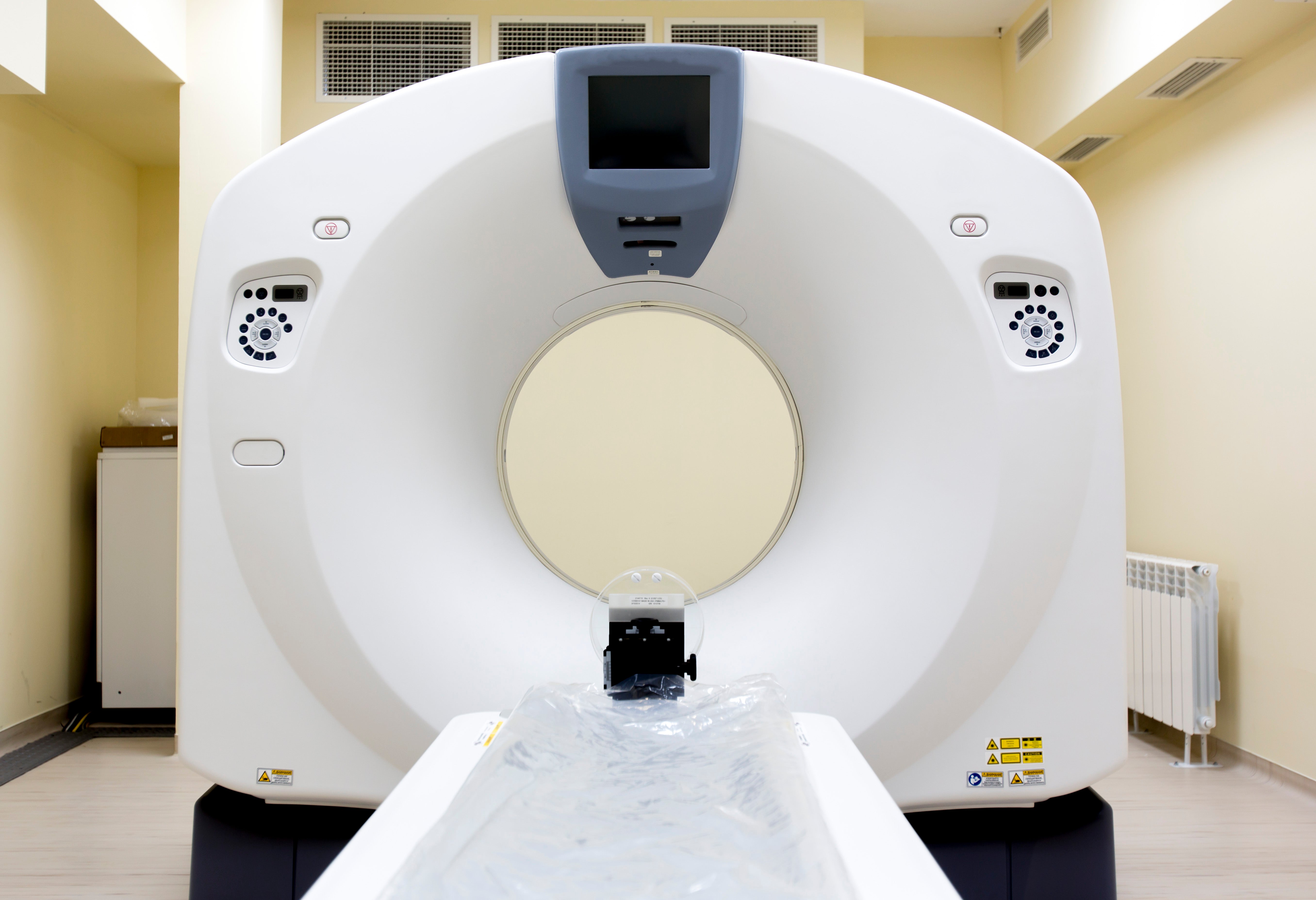 CT scanner bore opening with display screen and patient positioning equipment